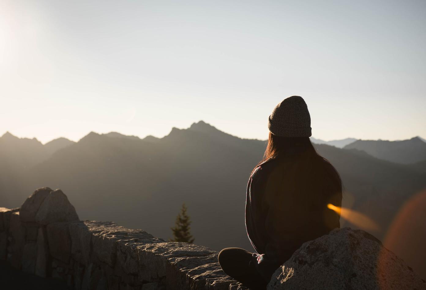 Person with back to camera overlooking a craggy range of hills