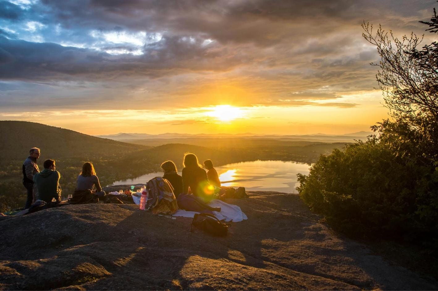 People picnicking while the sun sets